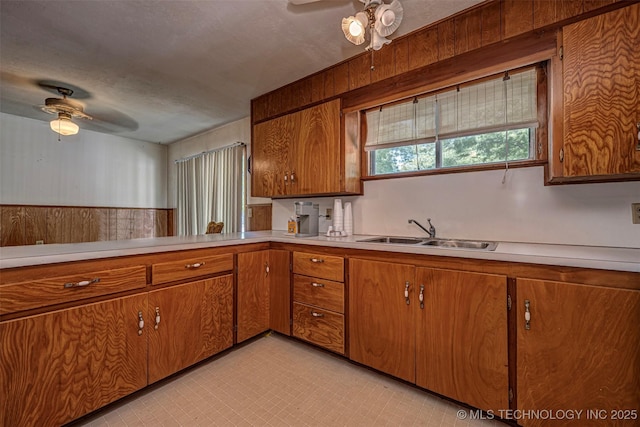 506 S 8th, Davis, OK 73030 - kitchen with ceiling fan, a sink, brown cabinetry, light countertops, and a textured ceiling