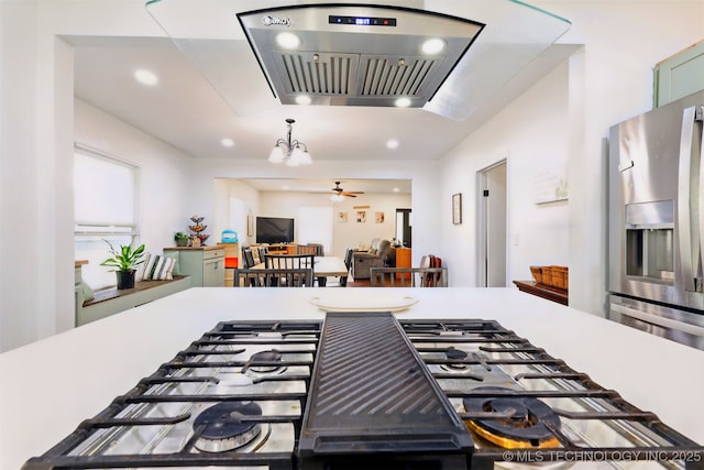 1206 S Osage Ave, Bartlesville, OK 74003 - kitchen featuring stainless steel refrigerator with ice dispenser, wall chimney range hood, a ceiling fan, recessed lighting, and gas cooktop