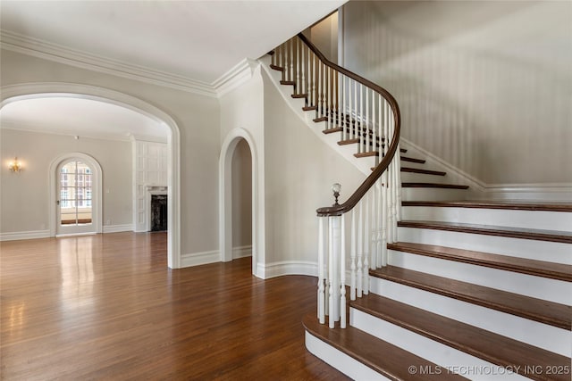 1217 Hazel Blvd, Tulsa, OK 74114 - staircase with arched walkways, wood finished floors, ornamental molding, and baseboards