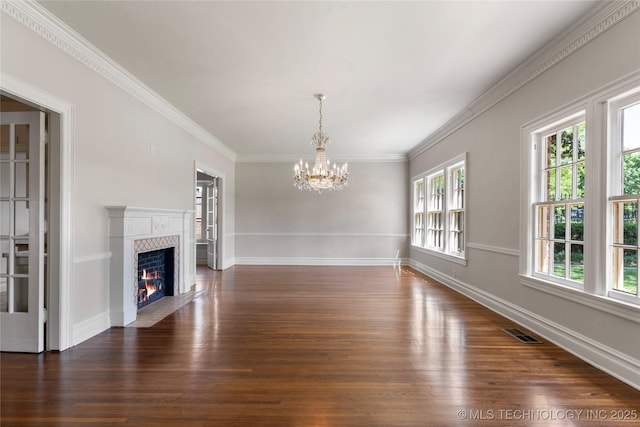 1217 Hazel Blvd, Tulsa, OK 74114 - unfurnished living room featuring healthy amount of natural light, dark wood-style floors, a chandelier, a high end fireplace, and crown molding