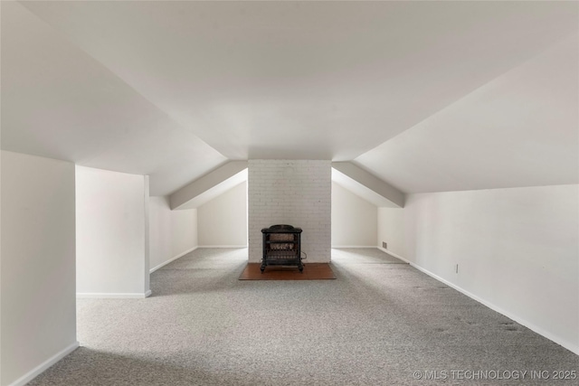 1217 Hazel Blvd, Tulsa, OK 74114 - additional living space featuring carpet, vaulted ceiling, baseboards, and a wood stove
