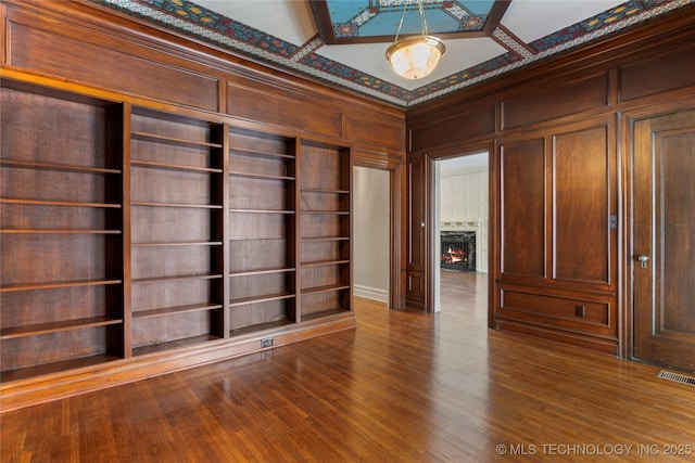 1217 Hazel Blvd, Tulsa, OK 74114 - spare room with a lit fireplace and wood finished floors