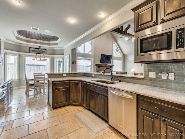 7605 E 82nd Pl, Owasso, OK 74055 - kitchen with appliances with stainless steel finishes, a sink, a raised ceiling, healthy amount of natural light, and crown molding
