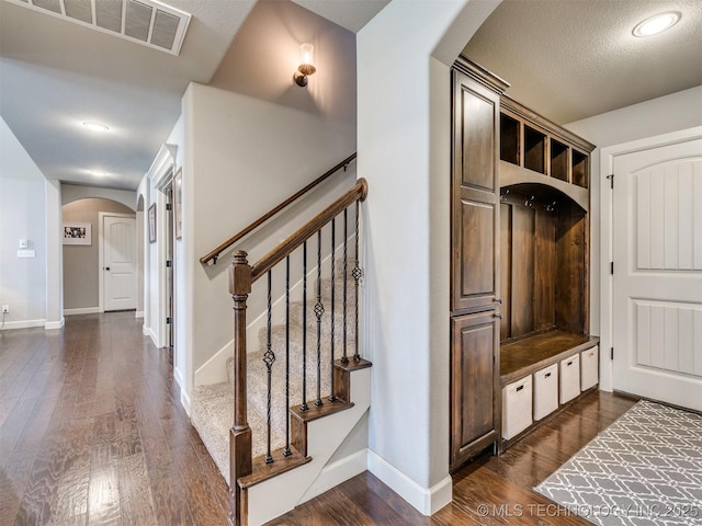 7605 E 82nd Pl, Owasso, OK 74055 - mudroom featuring arched walkways, dark wood-style floors, and baseboards