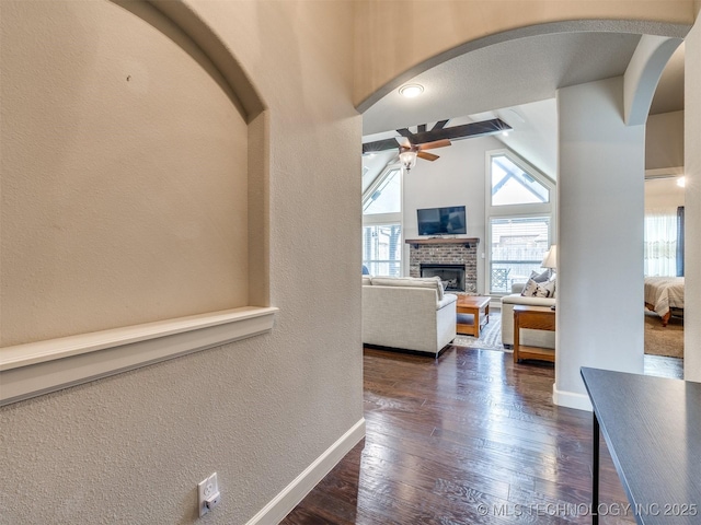 7605 E 82nd Pl, Owasso, OK 74055 - hallway with arched walkways, dark wood-type flooring, baseboards, and a textured wall
