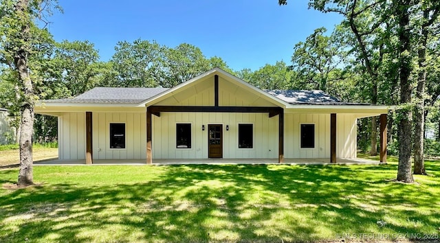 12443 Longboard Loop, Kingston, OK 73439 - view of front facade with board and batten siding, a front lawn, a shingled roof, and a patio area