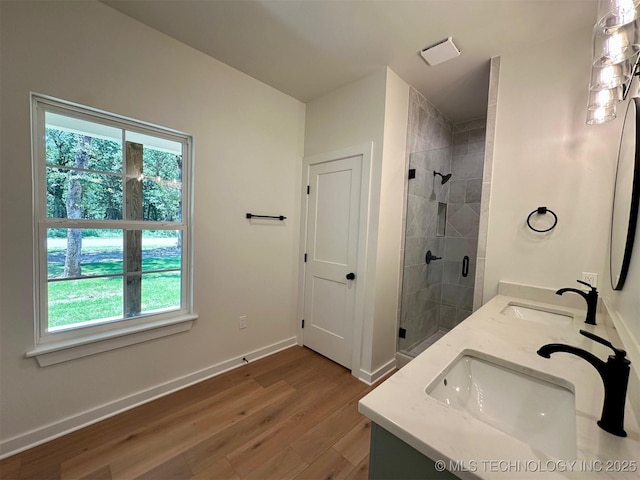 12443 Longboard Loop, Kingston, OK 73439 - full bathroom featuring healthy amount of natural light, double vanity, a stall shower, and wood finished floors