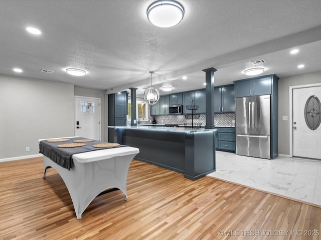 10931 E 4th Pl, Tulsa, OK 74128 - kitchen with stainless steel appliances, a textured ceiling, baseboards, backsplash, and blue cabinetry