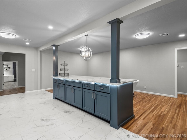 10931 E 4th Pl, Tulsa, OK 74128 - kitchen with decorative columns, baseboards, light stone countertops, pendant lighting, and light marble finish flooring