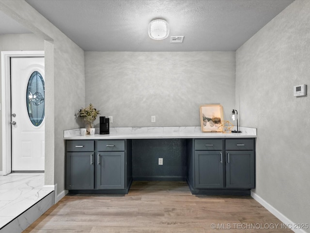 10931 E 4th Pl, Tulsa, OK 74128 - washroom featuring a textured wall, light wood finished floors, a textured ceiling, and baseboards