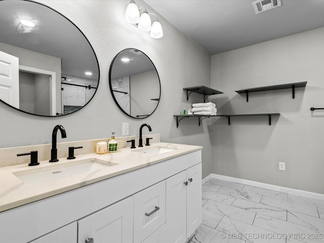 10931 E 4th Pl, Tulsa, OK 74128 - bathroom featuring marble look tiles, double vanity, and baseboards