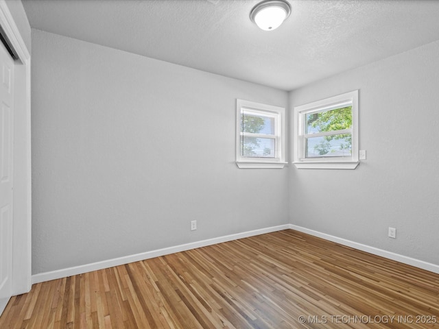 10931 E 4th Pl, Tulsa, OK 74128 - unfurnished room with light wood-style flooring, baseboards, and a textured ceiling