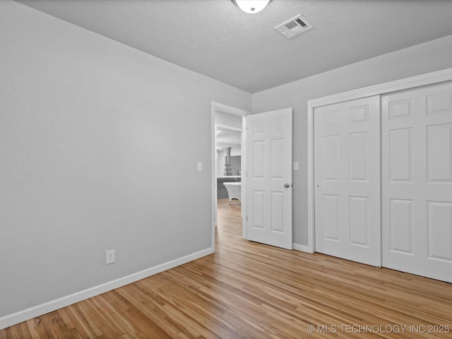 10931 E 4th Pl, Tulsa, OK 74128 - unfurnished bedroom with baseboards, light wood-style floors, and a closet