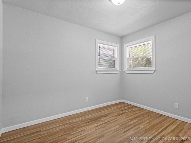 10931 E 4th Pl, Tulsa, OK 74128 - unfurnished room with light wood-type flooring, baseboards, and a textured ceiling