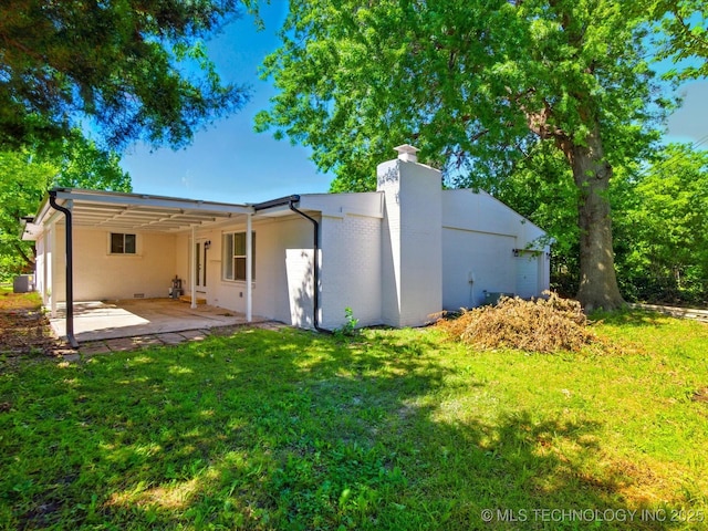 10931 E 4th Pl, Tulsa, OK 74128 - rear view of property with a chimney, a patio area, and a yard