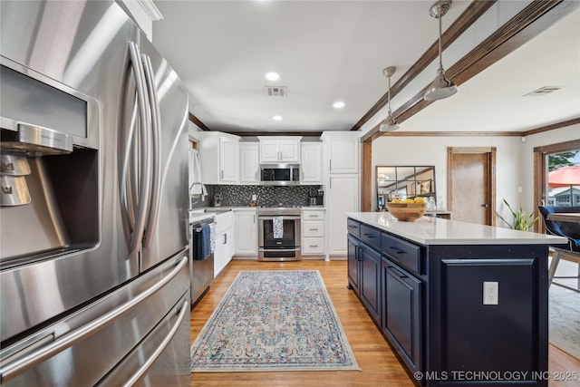 4341 E 56th Pl, Tulsa, OK 74135 - kitchen featuring appliances with stainless steel finishes, white cabinets, blue cabinets, light wood-style flooring, and a center island