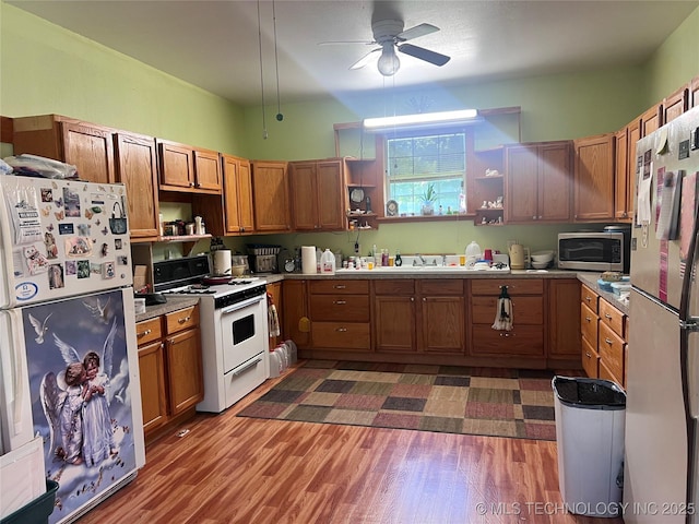 101 N 3rd St, Hartshorne, OK 74547 - kitchen with open shelves, white appliances, ceiling fan, and brown cabinetry