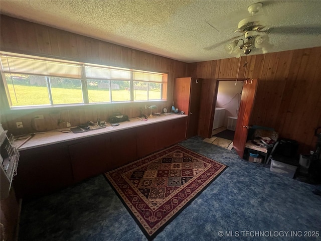 101 N 3rd St, Hartshorne, OK 74547 - kitchen featuring wood walls, ceiling fan, carpet floors, a textured ceiling, and brown cabinets