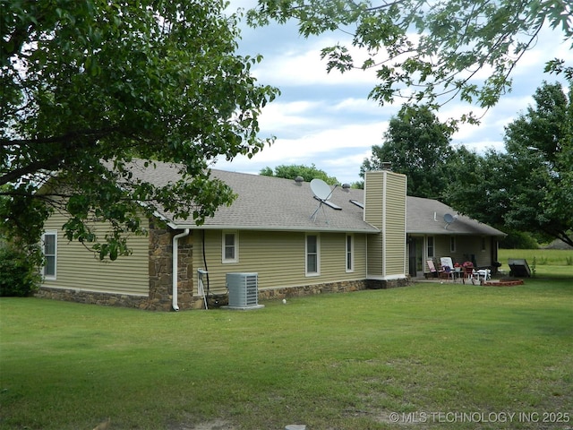 173 County Road 5305th Rd, Wynona, OK 74084 - back of property featuring a chimney, central air condition unit, a patio area, a lawn, and roof with shingles