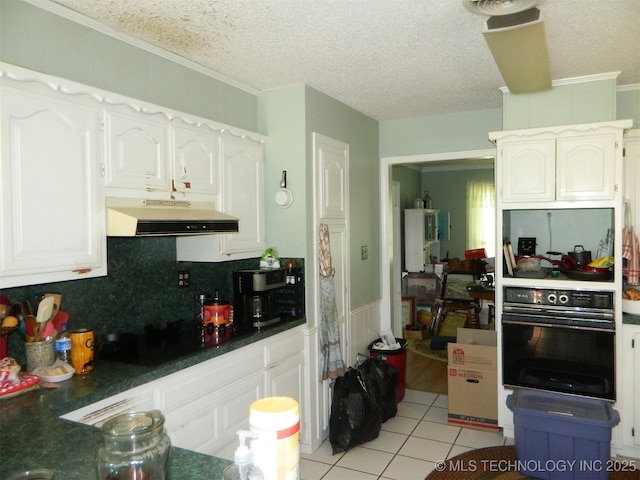173 County Road 5305th Rd, Wynona, OK 74084 - kitchen with under cabinet range hood, black appliances, light tile patterned floors, white cabinetry, and ornamental molding