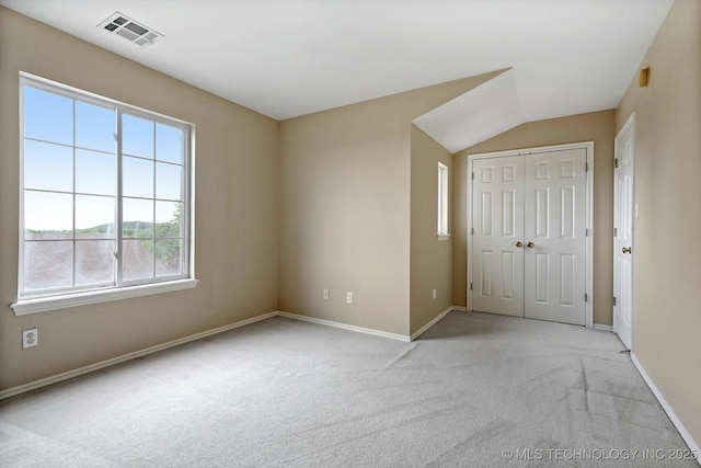 6007 E 76th Ct, Tulsa, OK 74136 - unfurnished bedroom with light carpet, multiple windows, baseboards, a closet, and lofted ceiling