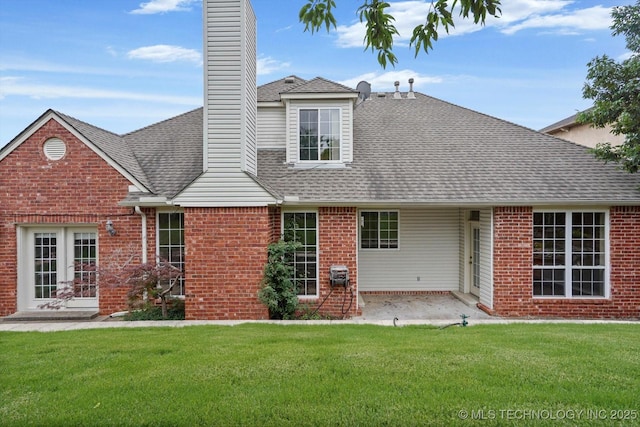 6007 E 76th Ct, Tulsa, OK 74136 - rear view of house with brick siding, a chimney, a lawn, a patio, and a shingled roof