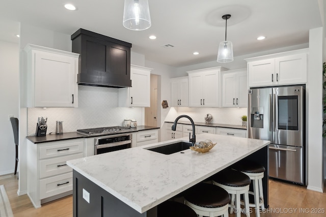 13859 S 21st Pl E, Bixby, OK 74008 - kitchen featuring stainless steel appliances, a sink, custom exhaust hood, light wood finished floors, and white cabinets