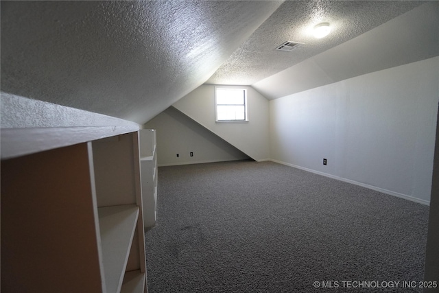 8304 E 124th E Ave, Owasso, OK 74055 - bonus room with a textured ceiling, carpet floors, vaulted ceiling, and baseboards