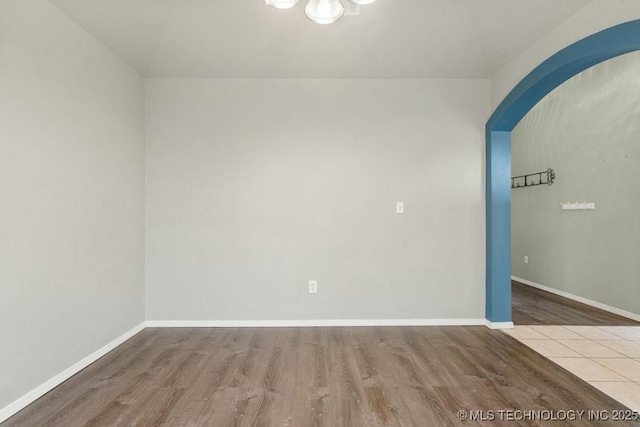 20001 E 46th St, Broken Arrow, OK 74014 - spare room featuring wood finished floors, lofted ceiling, a chandelier, baseboards, and arched walkways