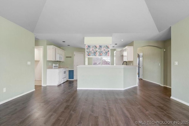 20001 E 46th St, Broken Arrow, OK 74014 - unfurnished living room with dark wood-type flooring, baseboards, arched walkways, and vaulted ceiling