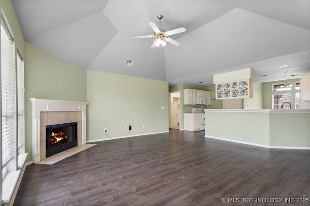 20001 E 46th St, Broken Arrow, OK 74014 - unfurnished living room with a tiled fireplace, a ceiling fan, dark wood-style flooring, high vaulted ceiling, and baseboards