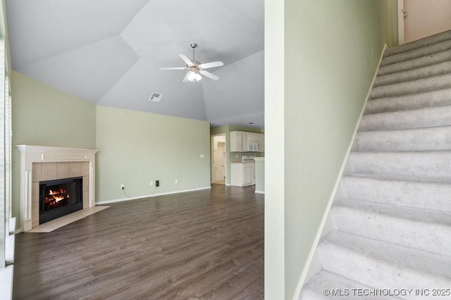 20001 E 46th St, Broken Arrow, OK 74014 - stairway featuring ceiling fan, wood finished floors, a tile fireplace, baseboards, and high vaulted ceiling
