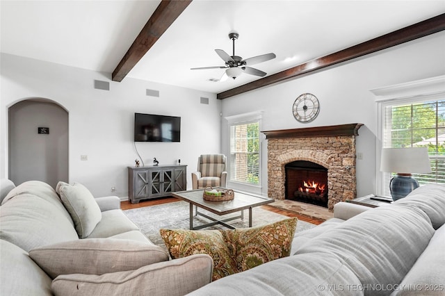 10935 S 77th Pl, Tulsa, OK 74133 - living area with beamed ceiling, arched walkways, ceiling fan, wood finished floors, and a stone fireplace