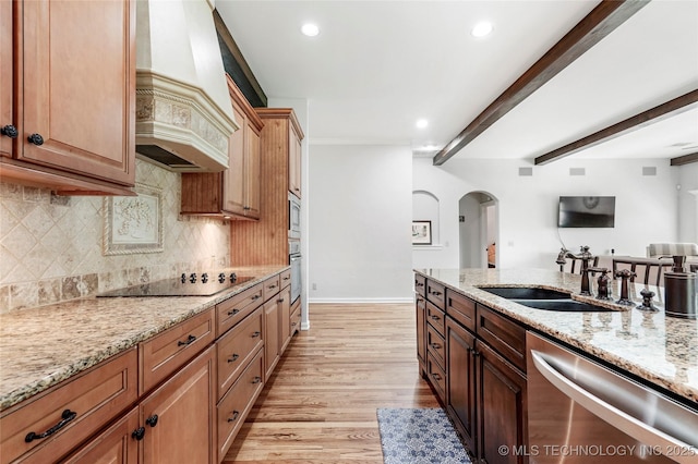 10935 S 77th Pl, Tulsa, OK 74133 - kitchen featuring appliances with stainless steel finishes, arched walkways, a sink, premium range hood, and backsplash