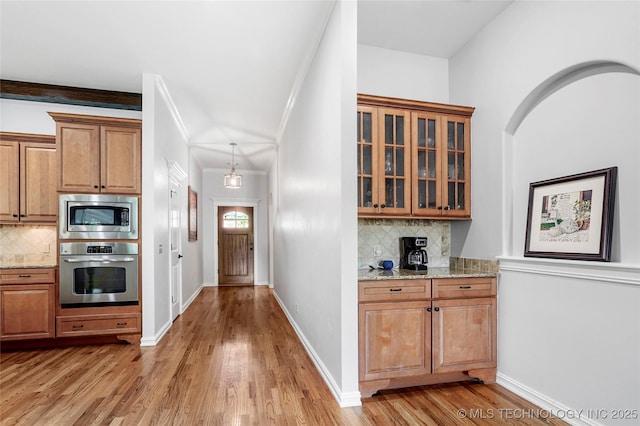 10935 S 77th Pl, Tulsa, OK 74133 - kitchen with stainless steel appliances, decorative backsplash, light wood-style floors, and light stone counters