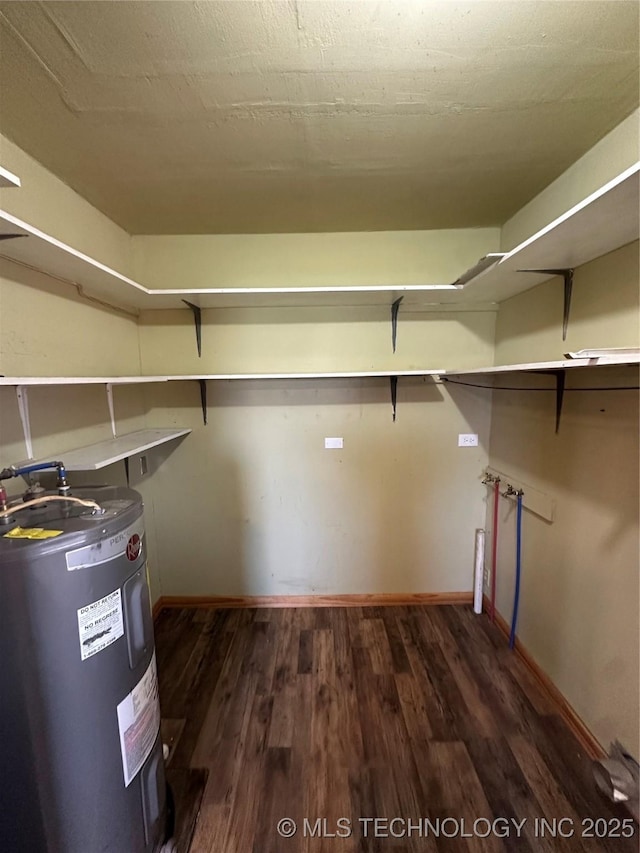 105 S B, Davis, OK 73030 - walk in closet featuring electric water heater and dark wood-type flooring