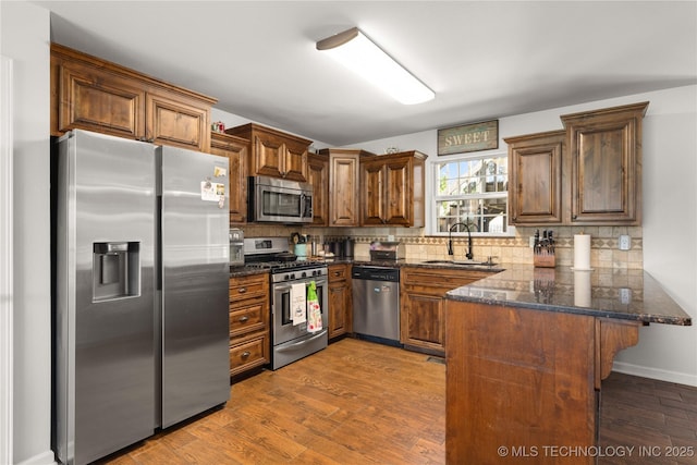 1608 Blue Stem Rd, Fort Gibson, OK 74434 - kitchen featuring appliances with stainless steel finishes, a sink, a peninsula, and decorative backsplash