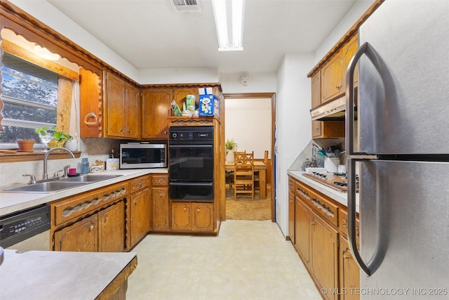 709 N Maple, Konawa, OK 74849 - kitchen featuring black appliances, a sink, a warming drawer, light floors, and under cabinet range hood