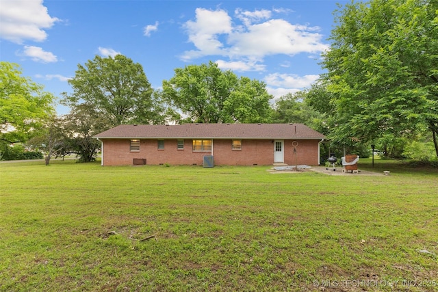 709 N Maple, Konawa, OK 74849 - rear view of house featuring a yard, a patio area, brick siding, and an outdoor fire pit
