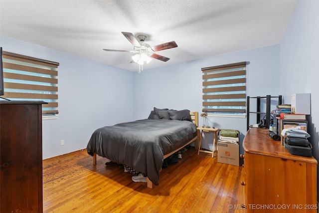 709 N Maple, Konawa, OK 74849 - bedroom with hardwood / wood-style flooring, a textured ceiling, baseboards, and ceiling fan