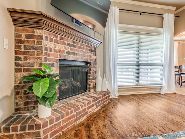 5909 E 139th St, Collinsville, OK 74021 - detailed view of wood finished floors, crown molding, and a brick fireplace
