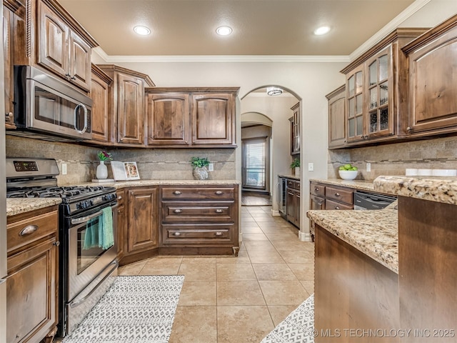 5909 E 139th St, Collinsville, OK 74021 - kitchen with stainless steel appliances, arched walkways, tasteful backsplash, light stone counters, and ornamental molding