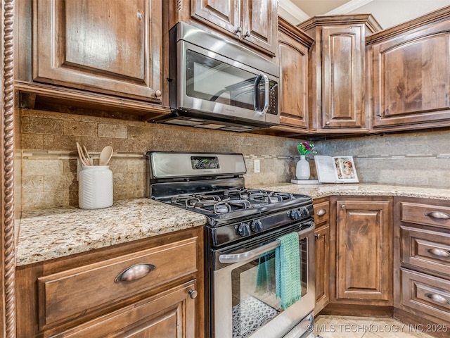 5909 E 139th St, Collinsville, OK 74021 - kitchen with stainless steel appliances, decorative backsplash, light stone counters, and brown cabinets