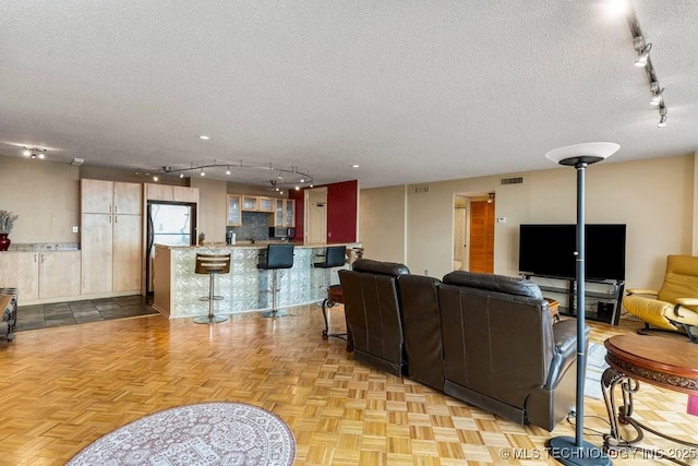 1502 S Boulder Ave Unit 16Cd, Tulsa, OK 74119 - living area featuring rail lighting, a textured ceiling, and baseboards