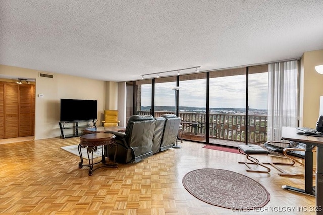 1502 S Boulder Ave Unit 16Cd, Tulsa, OK 74119 - living area with a wall of windows, a textured ceiling, and rail lighting