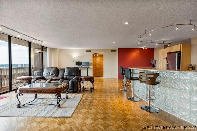 1502 S Boulder Ave Unit 16Cd, Tulsa, OK 74119 - living room with rail lighting, a textured ceiling, and bar