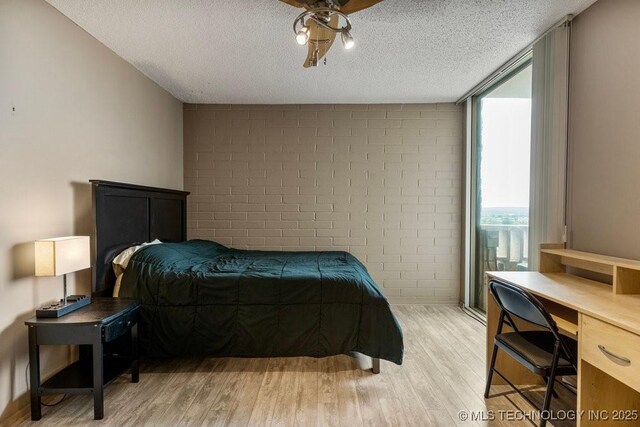 1502 S Boulder Ave Unit 16Cd, Tulsa, OK 74119 - bedroom featuring light wood-style flooring, a textured ceiling, an office area, and a ceiling fan