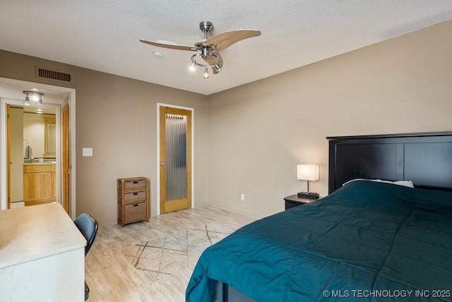 1502 S Boulder Ave Unit 16Cd, Tulsa, OK 74119 - bedroom with light wood-style floors, baseboards, a textured ceiling, and a ceiling fan