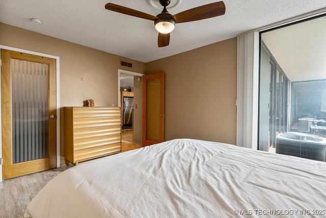 1502 S Boulder Ave Unit 16Cd, Tulsa, OK 74119 - bedroom with wood finished floors, a textured ceiling, and a ceiling fan