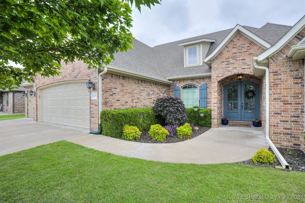 5414 Aspen Ave, Bartlesville, OK 74006 - view of front of home with a shingled roof, french doors, concrete driveway, and brick siding